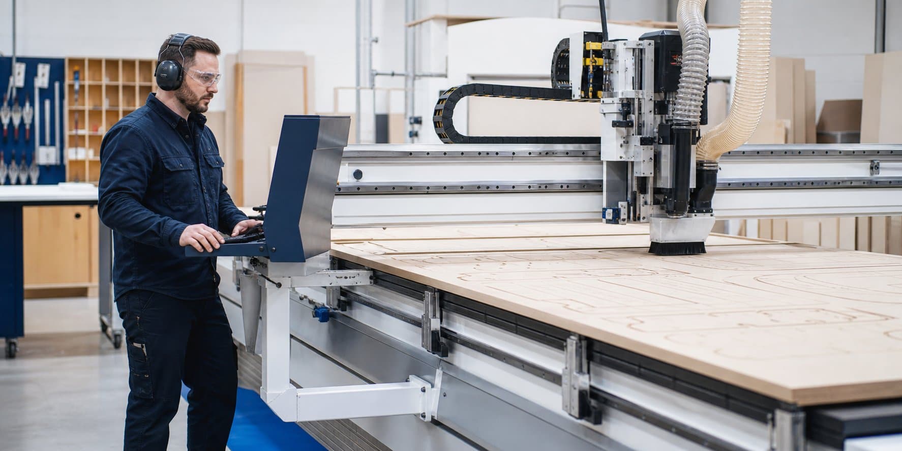 A professional CNC operator supervising a large-format router